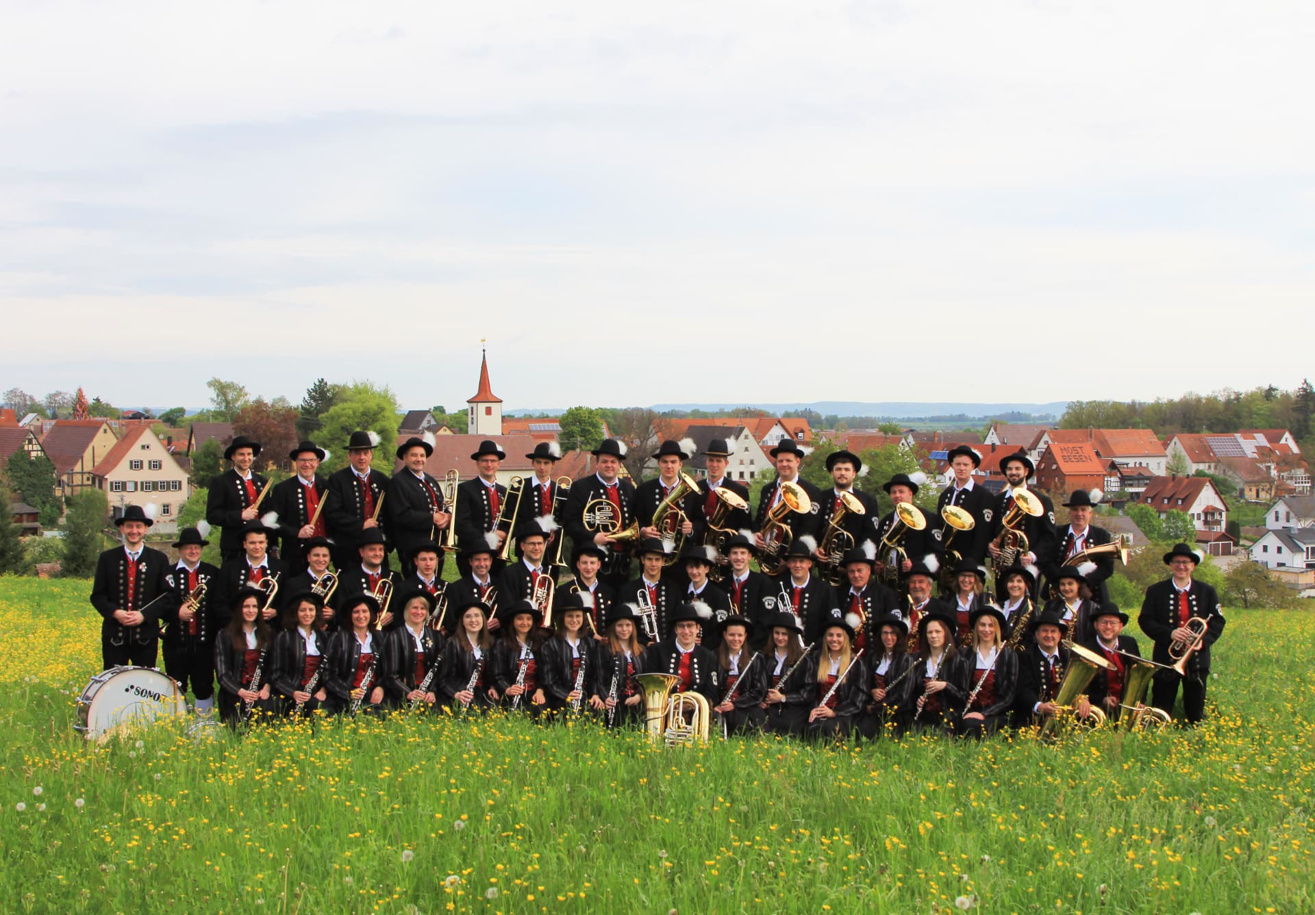 Musikerinnen und Musiker des Musikvereins Wolfenhausen vor der Dorfkulisse