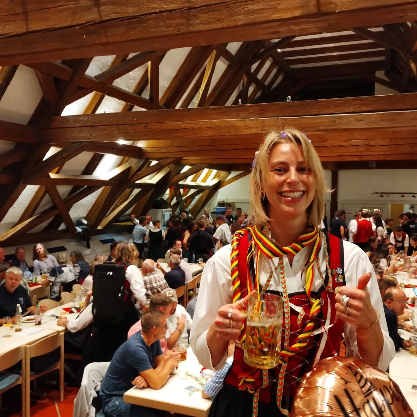 Musikerin in Tracht feiert im Festsaal mit Maßkrug